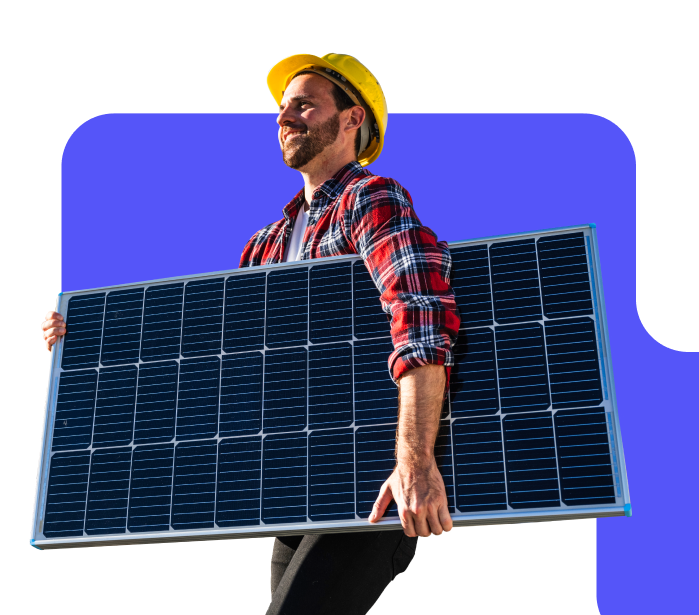Worker in hardhat carrying a solar panel.